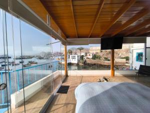 a bedroom with a large balcony with a view of the water at Lindo chalet en PUCUSANA in Pucusana