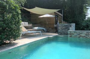 a swimming pool with a bench and an umbrella at Tiny-Pool-Lake in Viviers-du-Lac