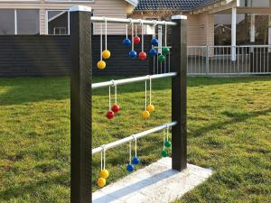 a swing set with balls in a yard at Luxury Pool Retreat by Sea - By Traum Ferienwohnungen in Bogense