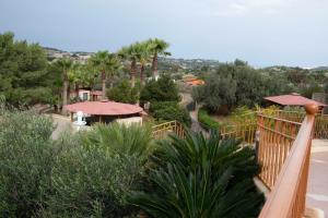 a view of a garden with palm trees and a balcony at Fun for all the family! in Żebbieħ