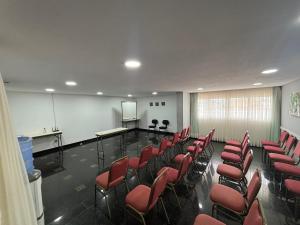a lecture room with red chairs and a screen at Flat Praia de PontaNegra - Natal RN in Natal +18 photos