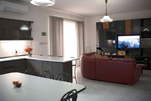 a kitchen and living room with a couch and a table at Fun for all the family! in Żebbieħ