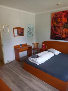 a bedroom with a bed and a desk in it at Hotel Restaurant zur Gondel in Bitterfeld