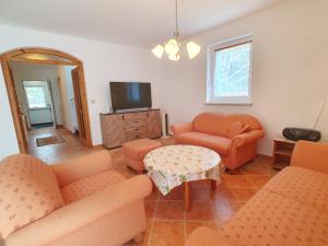 a living room with orange furniture and a tv at Nr 75 Holiday house Sigrid and Alfred in Gyenesdiás