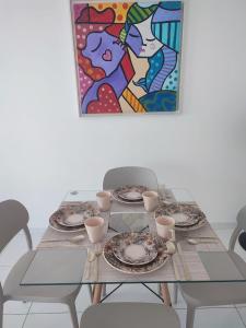 a table with plates and cups on top of it at STUDIO URBANO Ar Garagem 2 Quartos in Petrolina