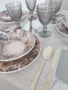 a table with plates and wine glasses and a spoon at STUDIO URBANO Ar Garagem 2 Quartos in Petrolina +22 photos