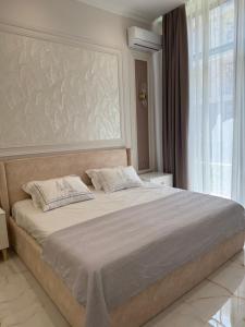 a bedroom with a large bed and a large window at Seabreeze Polo Residence in Nardaran