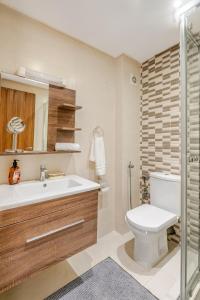 a bathroom with a toilet and a sink and a shower at Grand Appartement de standing sécurisé, proche plage avec piscine privée in Bouznika