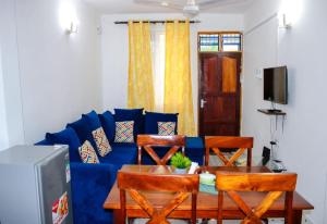 a living room with a blue couch and a table at Mjhomes in Mtwapa
