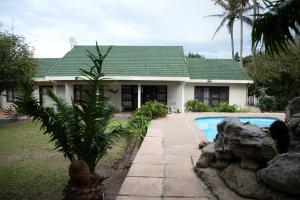 una casa con piscina delante en whales tail, en Port Shepstone