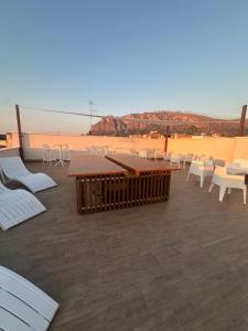 Un patio con mesas y sillas y vista al desierto. en Ma Gra Ví, en Terrasini