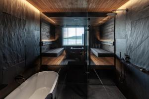 a large bathroom with a tub and a shower at The Lakeview by Hilla Villas in Äkäslompolo
