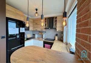 una cocina con mesa y algunas luces en Postcard Apartment Scenic Escape 10 Minutes to Gdańsk Old Town and Seaside, en Gdansk
