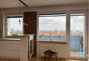 cocina con ventana grande con vistas a la ciudad en Postcard Apartment Scenic Escape 10 Minutes to Gdańsk Old Town and Seaside, en Gdansk