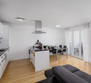 a white living room with a couch and a table at City Apartment in Opfikon