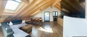 a living room with a couch and a table with chairs at FeWo Leni - Modernes Apartment mit Bergblick - Zentral gelegen in Mittenwald