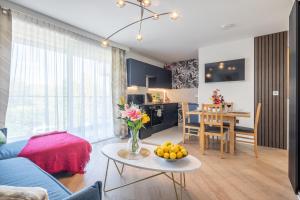 a living room with a couch and a table with a vase of flowers at Trinity- New Modern Apartment with FREE on road parking in Cambridge