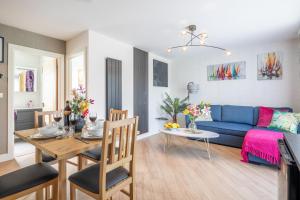 a living room with a blue couch and a table at Trinity- New Modern Apartment with FREE on road parking in Cambridge