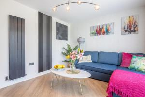 a living room with a blue couch and a table at Trinity- New Modern Apartment with FREE on road parking in Cambridge