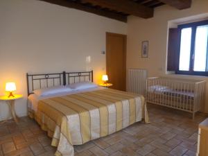 ウルビーノにあるAgriturismo Valdappioのベッドルーム1室(ベッド1台、テーブルにランプ2つ付)