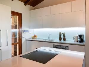 una cucina con mobili bianchi e un piano di lavoro di LuxRent Villa Smeralda Pool and Beach a Capo Coda Cavallo