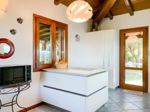 una cucina con mobili bianchi e un forno a microonde di LuxRent Villa Smeralda Pool and Beach a Capo Coda Cavallo
