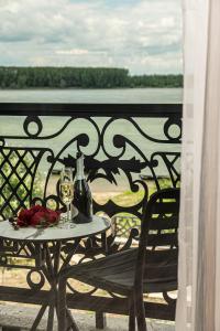 a table with wine glasses and flowers on a balcony at Danubius View - Luxury Hotel and Hall in Kozloduy