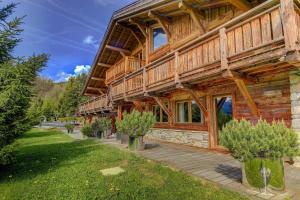 a large log cabin with a lawn in front of it at Megeve Luxury Estate The Royal Alpine Retreat with Mont Blanc View in Demi-Quartier