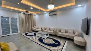 a living room with couches and a flat screen tv at Beachside villa with a pool! in Karzakkān