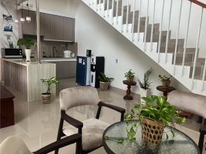 a kitchen with a glass table and chairs and stairs at D'illy Borobudur Villa in Magelang