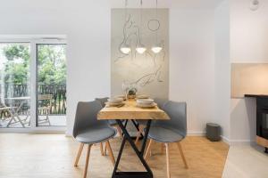 a dining room with a wooden table and chairs at Dolina Szczęścia Apartamenty Pine - Dream Apart in Szklarska Poręba