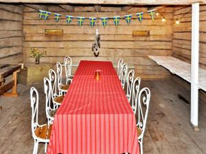 a red table and chairs in a room with flags at 8 person holiday home in Vargön in Västra Tunhem