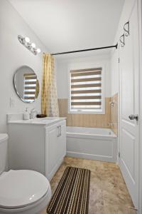 a bathroom with a toilet and a tub and a sink at Cozy Comfort Escape - Your Next Memorable Retreat in Brampton +23 photos