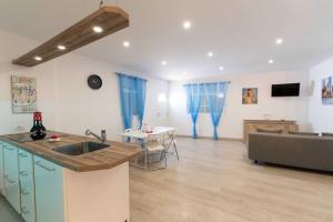a kitchen and living room with a sink and a couch at Apartamento acogedor con Piscina en Tenerife in Icor