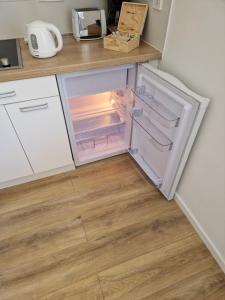 an open refrigerator with its door open in a kitchen at Apartment Sunset in Zalakaros