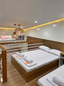 a bedroom with two beds and a kitchen at The Tree House - Loft Unit - Vigan in Vigan