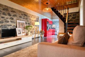 a living room with a couch and a tv at Valley Canhas I in Relógio do Poiso