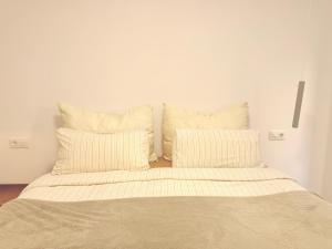 a bed with white sheets and pillows in a room at Ola A Coruña in A Coruña +6 photos