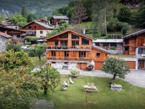 una gran casa de madera en medio de un pueblo en Les Moulins D'Angelina - OVO Network, en Séez