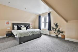 a bedroom with a large bed and a window at Elegant Victorian Home with Pool Table & Parking in Cardiff