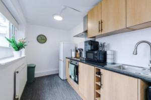 a kitchen with a sink and a refrigerator at 2 Bed apartment, sleeps up to 5 in Blackpool