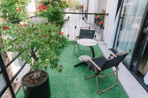 a balcony with two chairs and a table and a potted plant at Blue Sea Hotel in Cam Lâm