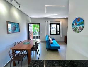 a living room with a table and a blue couch at Apto Funcional próximo a Orla do Centro HS4 in Ubatuba