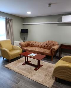 a living room with a couch and two chairs and a table at Best Western Ipswich Hotel in Ipswich