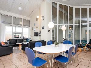 a dining room with a table and blue chairs at 10 person holiday home in Haderslev-By Traum in Diernæs