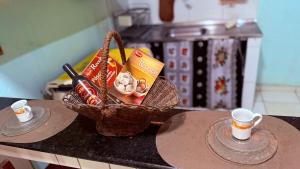 a basket on a table with two cups of coffee at Beach house in Búzios with pool in Nísia Floresta