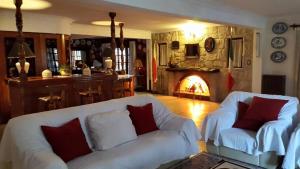 a living room with two white couches and a fireplace at Hotel Villa Santa Maiani in Mar del Plata