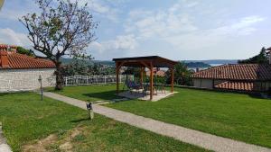 un cenador con un banco en un patio en Villa Senegačnik, en Portorož