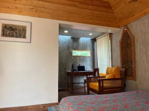 a bedroom with a bed and a desk and a chair at Rimil Homestay Santiniketan in Shānti Niketan