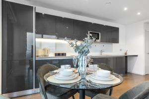 un tavolo da pranzo con un vaso di fiori sopra di Sky High Luxury 2 Bed Flat with Jaw Dropping Views a Moffat